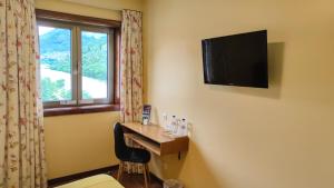 福斯图阿卡萨都图阿酒店的酒店客房设有一张桌子和一台墙上的电视