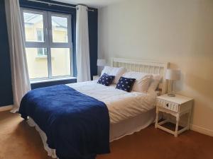纽卡斯尔Seafront Apartment的一间卧室配有一张带蓝色毯子的床和窗户。