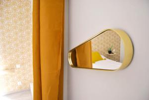 第戎图洛特酒店的一面墙上的镜子,上面有黄色窗帘