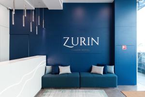 里斯本Zurin Charm Hotel的大堂的蓝色墙壁和蓝色的沙发