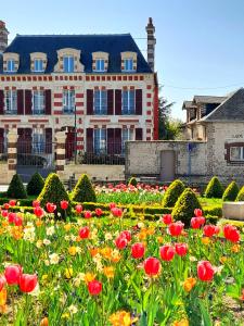 滨海迪沃Demeure de Manneville - SPA - 1Km des plages de Cabourg的一座建筑前的鲜花花园