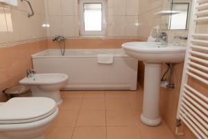 奥托查茨米尔尼库塔克酒店的浴室配有盥洗盆、卫生间和浴缸。