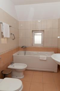 奥托查茨米尔尼库塔克酒店的带浴缸、卫生间和盥洗盆的浴室