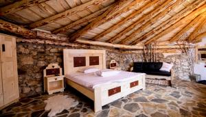 米奥修德萨斯Odai din Plai的卧室配有一张石墙内的大床