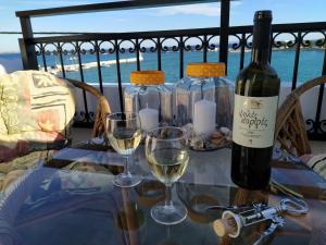 毕达哥利翁Aegean Blu Port House Pythagoreio的桌子上放有一瓶葡萄酒和两杯酒