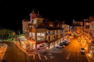 皮拉图巴Hotel Rouxinol的夜间在街上停车的城市