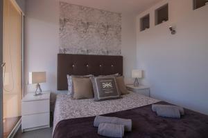 奎特里拉SUITE ON 7TH VILAMOURA THE BEST VIEW IN TOWN - 1Br的一间卧室配有一张大床,设有两个床头柜和两盏灯