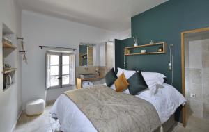 卢马罕La Maison de Lourmarin的一间卧室设有一张蓝色墙壁的大床