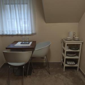 班斯卡-比斯特里察Penzion Hastrman的客房设有桌子、两把椅子和窗户。