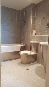 卡迪夫夜空服务式公寓的浴室配有卫生间、盥洗盆和浴缸。