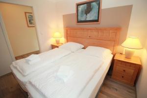 阿舍贝格Ferienwohnung Seeblick Plöner See的一间卧室配有一张带白色床单和两盏灯的床。