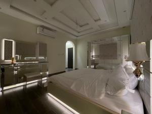 塔伊夫Luxury OVO Roof Villa的一间卧室配有一张床、一张桌子和一盏灯