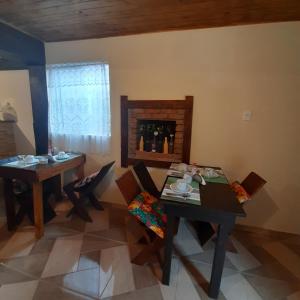 拉夫拉斯诺瓦斯Luar de Minas suites的一间带2张桌子和椅子的用餐室以及壁炉