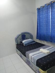 米里A&W Homestay, Vista Perdana, Miri的一间小卧室,配有床和蓝色窗帘