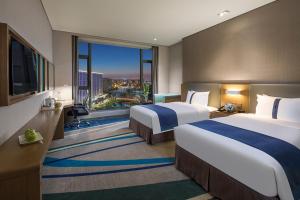 杭州杭州东站智选假日酒店 的酒店客房设有两张床和大窗户。