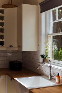 黑荒地拉兰吉精品度假屋的厨房配有白色水槽和窗户