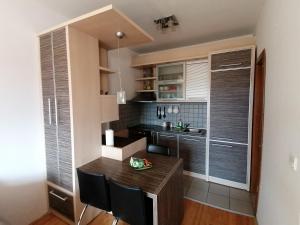 克鲁舍瓦茨Apartman Breza的一个带木桌和椅子的小厨房