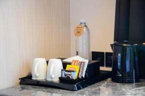 日惹The Manohara Hotel Yogyakarta的桌子上装有一瓶水的托盘