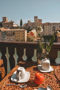 巴萨诺－德尔格拉帕Appartamenti Ponte Vecchio的阳台上的桌子上放着两杯和西红柿