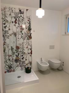 特伦托Manciuno的浴室的墙上装饰有花卉壁纸