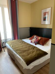 安锡诺德酒店的一间卧室配有一张带棕色毯子的大床
