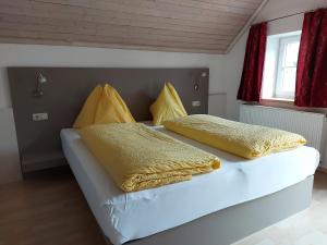 施特罗布尔K3 Ferienhaus的一间卧室配有两张带黄色枕头的床