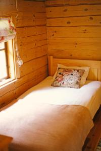 曼亚拉Niidupuu Camping的木制客房的一张床位,设有窗户