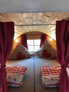 Wolframs-EschenbachHolz Fässla的一间小房子里的一张床位,上面有红色窗帘