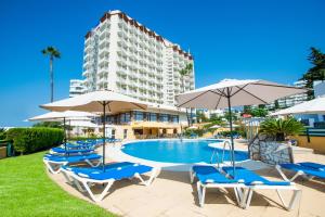 福恩吉罗拉托瑞布兰卡莫纳克酒店的一个带椅子和遮阳伞的游泳池和一座建筑