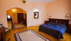 布拉索夫卡萨瓦格纳酒店的一间卧室配有一张带蓝色棉被的床
