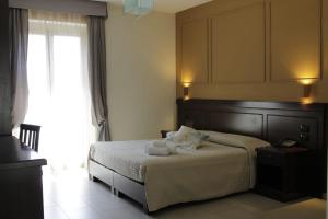 雷焦卡拉布里亚阿尔巴努欧瓦酒店的一间卧室配有一张床,上面有两条毛巾