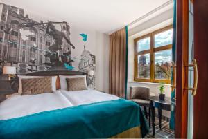 格但斯克汉扎酒店的一间卧室配有一张床、一张书桌和一个窗户。