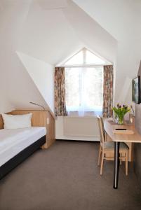 格洛韦格尼海景酒店的一间卧室配有一张床、一张桌子和一个窗户。