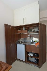 KiónionArgalios Studios的一个带木制橱柜和水槽的小厨房