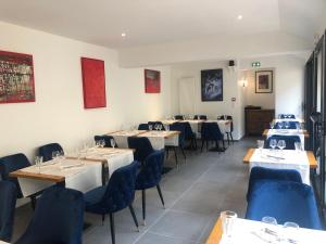 RospordenL'Otentik Restaurant Chambres d'Hôtes的一间配备有桌子和蓝色椅子的用餐室