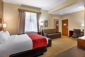 尤金Comfort Suites Eugene的酒店客房配有一张床、一把椅子和一张书桌