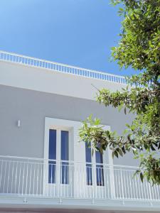 滨海波利尼亚诺Dimora Lilla的白色的房子设有蓝色的窗户和阳台