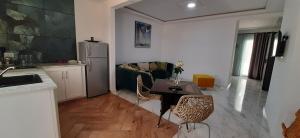 莫纳斯提尔LEO Haute standing appartment S1 center Monastir的厨房以及带桌子和沙发的客厅。