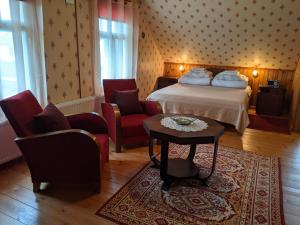 AvinurmeAvinurme Hostel的酒店客房配有一张床、两把椅子和一张桌子