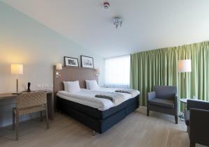 马斯特兰德马斯特兰德斯哈福斯酒店的一间卧室配有一张床、一张桌子和一把椅子