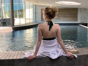 马斯特兰德马斯特兰德斯哈福斯酒店的坐在游泳池旁的穿着衣服的女人