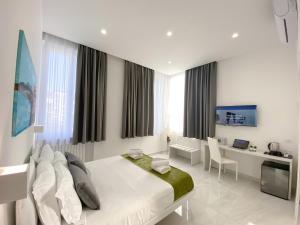 圣安吉洛Villa Gabriella - Rooms & Breakfast的一间白色的卧室,配有床、书桌和电脑