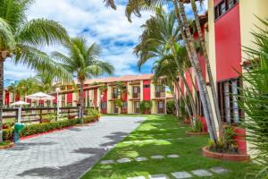 塞古罗港Casa Duplex 3 Suítes em Condomínio的穿过棕榈树度假村的庭院的步道