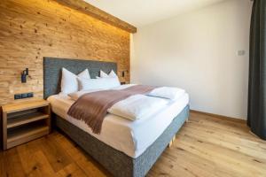 里约·迪·普斯特里亚App Mulin Loise mit Sauna的一间卧室设有一张大床和木墙