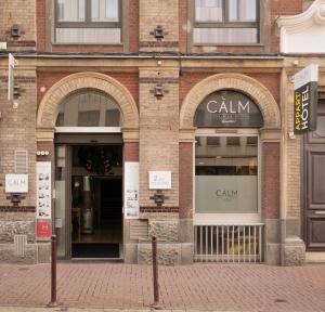 里尔CALM Appart' & Hostel的砖砌建筑前方的商店,设有两个大窗户
