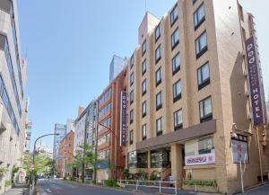 东京Pod Select Hotel Shinjuku的城市街道上一座高大的砖砌建筑