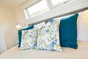 RingfordThe Pond Lodges Barstobrick的一张带蓝色和白色枕头的床和窗户