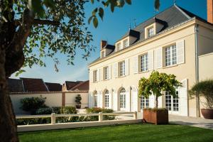 艾镇Les Chambres du Champagne Collery的享有带白色围栏的大房子的外部景色