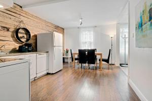 魁北克市Les Appartements du 790的厨房配有桌子和白色冰箱。