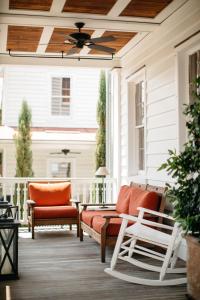 查尔斯顿The Charlestonian的门廊配有橙色椅子和吊扇